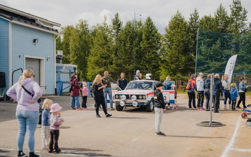 Yleisöä vanhan ralliauton ympärillä