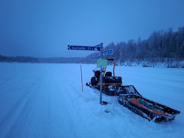 Kuvassa moottorikelkka ja reittimerkkejä