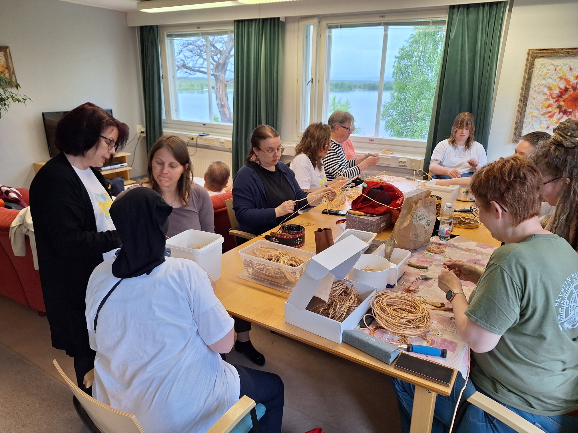 Ǩieʹssleirr 2026 root workshop Participants sitting around a table with roots and tools on it