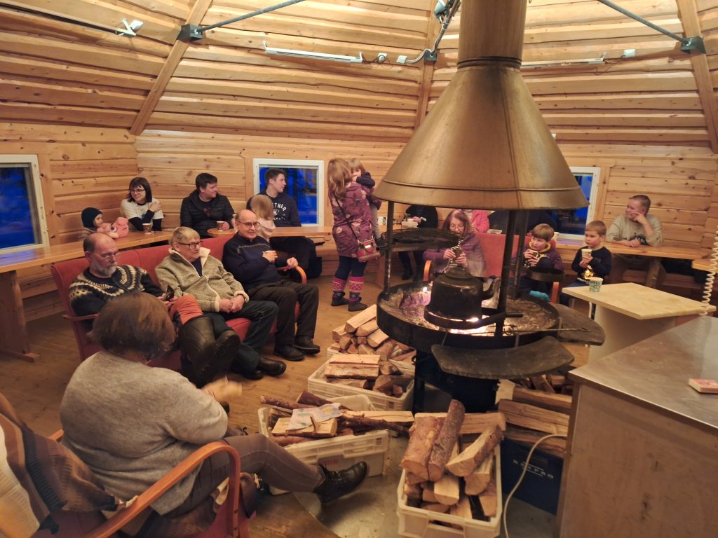 Camp participants gathered at a hut by open fire