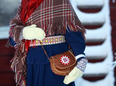 Kuvassa kolttasaamelainen nainen. Asuna perinteisiä asusteita. Kuva: Tanja Sanila
