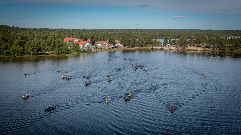 Kuvassa Sevettijärven koulun ranta. Rannasta lähtee Kairacross-kisaajia melomaan järvelle. Kuva: Poppis Suomela